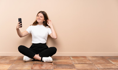 Ukrainian teenager girl sitting on the floor making a selfie