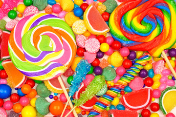 Fototapeta na wymiar Colorful background of assorted candies including lollipops, gum balls and jelly candies