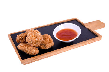 Hot Meat Dishes - Grilled Chicken Wings with Red Spicy Sauce. On a wooden board on a white background