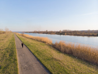 A woman on the path by the canal. Aerial photography.