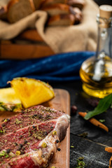 Raw meat on a wooden board with herbs and spices on a wooden platter with olive oil