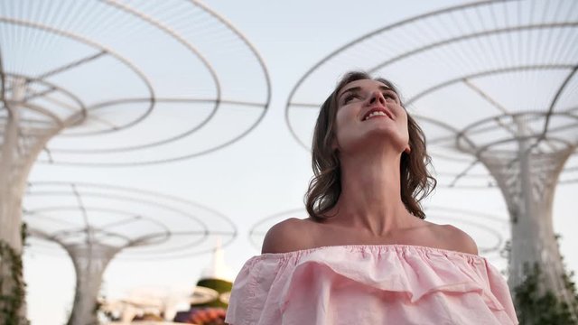Girl on the background futuristic metal flowers in Dubai Miracle Garden Park.