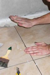 Installing ceramic tiles on the floor in the bath and toilet. The concept of reconstruction and improvement, home renovation, do-it-yourself workflow, accessories