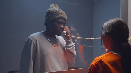 Visitor room in the prison. Man and woman are talking