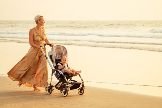 beautiful mother and her cute child walking before going to sleep on the beach