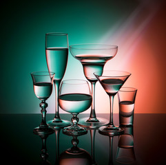 Six glass goblets on color gradient background