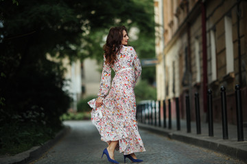 Naklejka premium Girl in a beautiful dress park in a flower