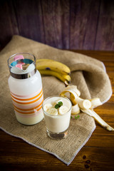 tasty homemade yogurt with bananas in a glass on a wooden table