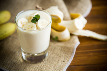 tasty homemade yogurt with bananas in a glass on a wooden table