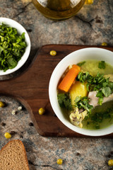 Chicken soup with herbs and green salad, top view