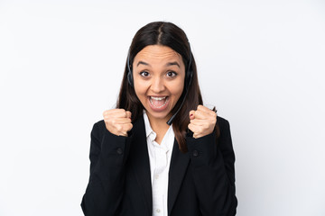 Young telemarketer woman isolated on white background celebrating a victory in winner position