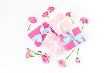 Floral composition of pink roses flowers and gifts on white background. Flat lay
