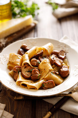 Pappardelle pasta with porcini mushrooms on a white plate, close up