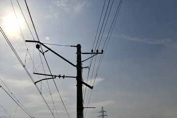 high voltage poles against gray sky