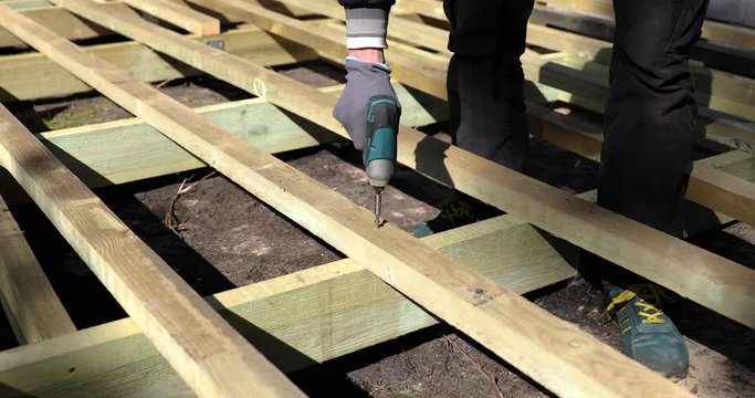 construction worker building wooden frame for patio terrace deck