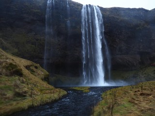 a waterfall in iIceland (Seljalandsfoss), clean water, cliff and water, field, nature in Iceland, South Iceland