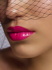 Cosmetics, makeup and trends. Bright lip gloss and lipstick on lips. Closeup of beautiful female...