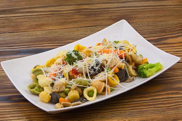 tasty appetizing pasta with vegetables on white plate