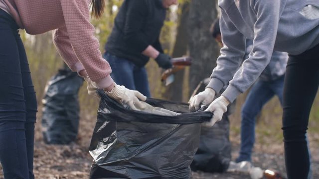 Women putting plastic trash in a bag