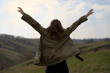 Alone girl on beautiful mountain view feeling free with wind  and sky. Isolated woman on nature background, freedom, post apocalypse