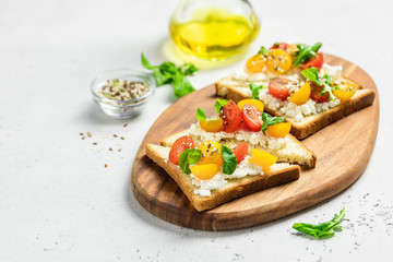 Cherry tomatoes cottage cheese toasts. Selective focus, copy space.