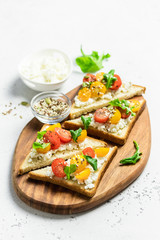 Cherry tomatoes cottage cheese toasts. Selective focus, copy space.