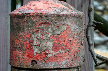The rusty surface of the once long painted metal hydrant as background.
