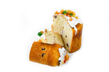 Sliced Easter cake with fondant and candied fruit on a white background.