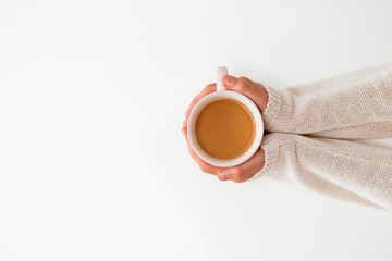 Female hands holding cups of coffee on white table background