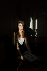 Obraz na płótnie Canvas the sun's rays fall on a girl sitting on a sofa at home
