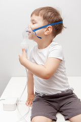 The boy makes inhalations. Treatment at home. Disease prevention