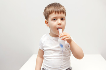 The boy makes inhalations. Treatment at home. Disease prevention