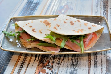 Piadina or Piada, thin Italian flatbread with smocked ham, arugula and ricotta cheese in San Marino