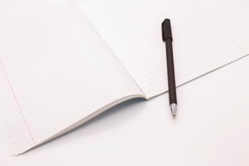 black fountain pen and notebook on a white background