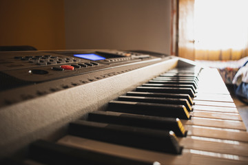  Close-up of a synthesizer keyboard on the table under the sunlight
