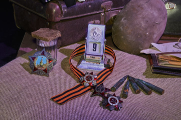 still life with a glass and a slice of brown bread, orders of the Second World War on canvas, a water flask, an old suitcase, rifle cartridges, an old calendar