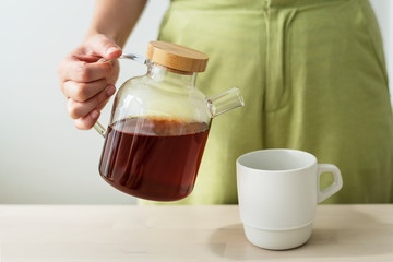 Woman pouring coffee to a cup