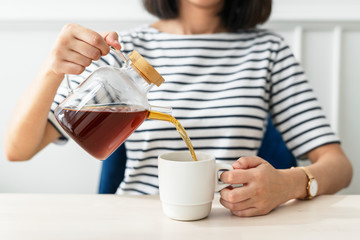 Woman pouring coffee to a cup