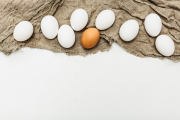 chicken eggs with a feather on a fabric on a white background, environmental friendliness, bright easter