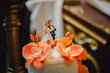 Bride and groom figures on wedding cake, closeup. Selective focus