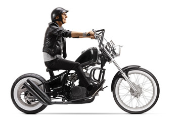Fototapeta na wymiar Elderly biker riding a chopper motorbike and wearing a helmet