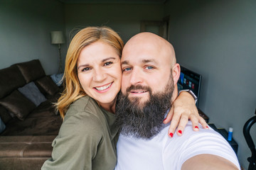 A couple takes a photo from the window of their house
