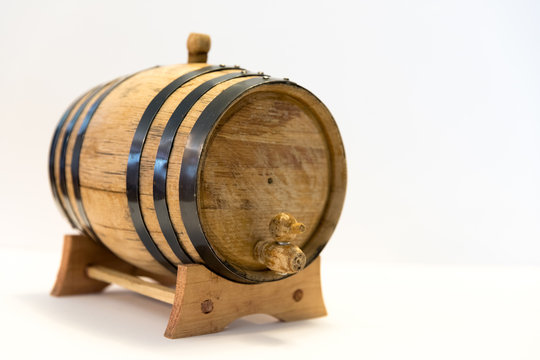 A Small Bourbon Barrel On A White Background. Corn Whiskey Is Aged For Varying Lengths Of Time In An Oak Barrel To Make Bourbon. Bourbon Is Usually Associated With The Southern US, Primarily Kentucky.