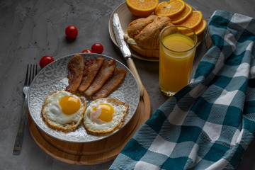 Classic fried egg, orange juice, orange and croissant breakfast