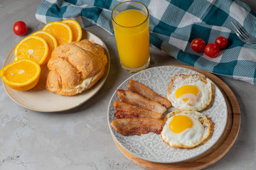 classic English breakfast with oatmeal, egg, toast, jam, bacon and butter balls on a wooden board
