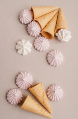 Small crispy waffle ice cream cups with colored marshmallows on a pastel background