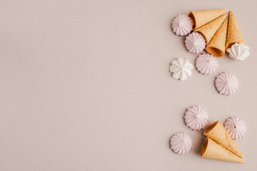 Small crispy waffle ice cream cups with colored marshmallows on a pastel background