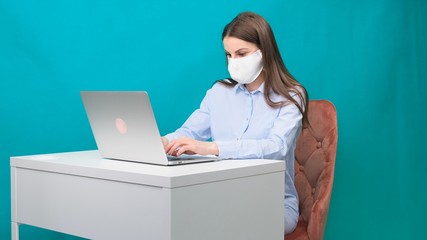 woman working at home with medical mask on face. coronavirus quarantine remote home working concept.