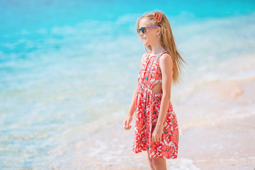 Adorable little girl have fun at tropical beach during vacation