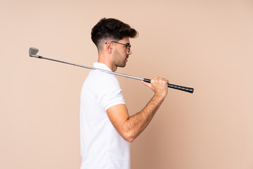 Young man over isolated background playing golf